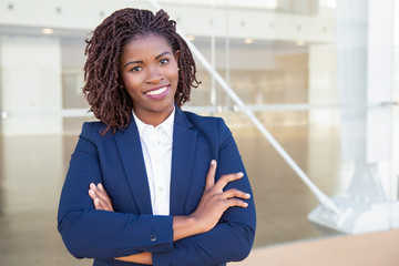 Happy successful professional posing near office building. Young African American business woman...