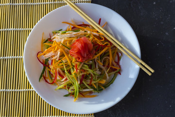 Asian style vegan salad bowl with vegetable mix on a dark background top close up