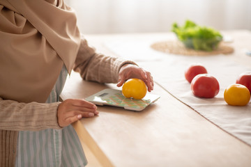 Close up of girl using kitchen scale while cooking