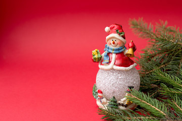 New year snowman with fir tree on red background, copy space. christmas holidays