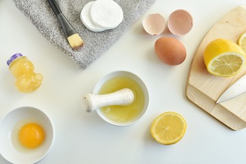 Natural acne treatment, homemade facial mask with lemon, egg white and honey, flat lay.