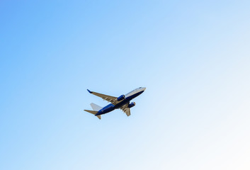 Naklejka na ściany i meble Big passenger plane flies in clear blue sky Aeroplane high up voyage