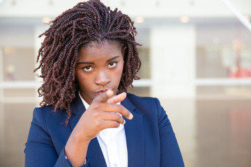 Fototapeta na wymiar Serious HR manager choosing you. Young African American business woman standing outside, looking and pointing finger at camera. Recruit agent or career concept