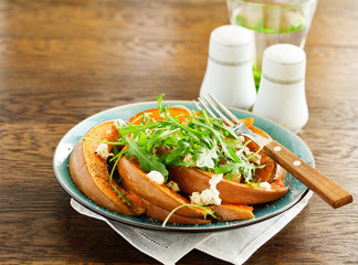 Baked pumpkin with feta and herbs. Selective focus