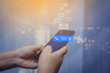 Contact us or Customer support hotline people connect. Businessman using a mobile phone with the (email, call phone, mail) icons.