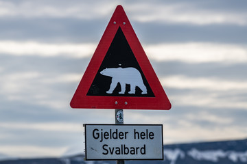 Polar bear warning sign in Longyearbyen, The texts under the sign means that the warning applies to...