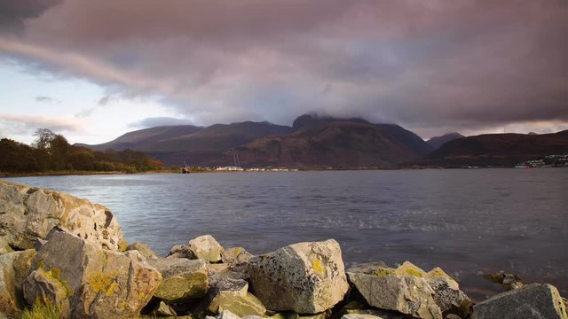 time lapse footage of the beach at corpach near fort william showing ben nevis in the background near sunset as stormy wintry clouds pass over the mountain