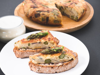 Vegetable omelette with asparagus on a sourdough bread slice. Asparagus tortilla on toast.  