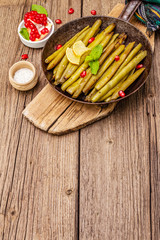 Baked green bean in pan with sesame seeds, pomegranate, mint and lemon