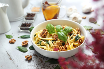 Spaghetti pasta in a cream sauce with fresh spinach, garlic, chicken and walnuts