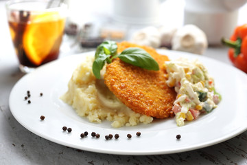 Vegetarian dinner. Vegetable cutlet in corn breadcrumbs with mashed potato, garlic and lemon, Chinese cabbage salad