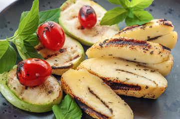 Slices of grilled halloumi cheese with courgettes, grilled tomatoes and mint. Traditional serving of halloumi cheese. Farm natural product