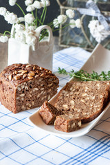 Freshly baked rye bread with seeds and raisins on sourdough without yeast on a white plate. Homemade cake. Fermentation process. Slow baking