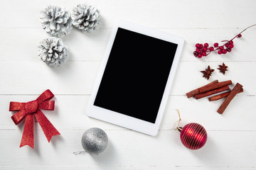 Mock up blank empty screen of tablet on the white wooden background with colorful holiday's decoration. Copyspace, negative space for your advertising. 31 of December, New Year concept.