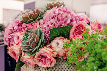 Beautiful bouquet of pink peony roses with exotic succulents roses. Trends in modern floristry....