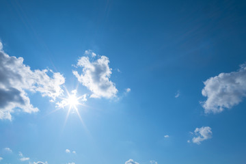 Naklejka na ściany i meble sparkle sun on a blue cloudy sky, natural outdoor background