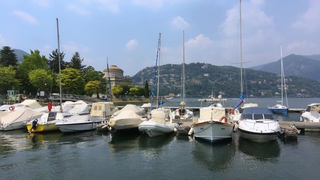 boats moored on como lake near the temple of Alessandro Volta in a sunny day