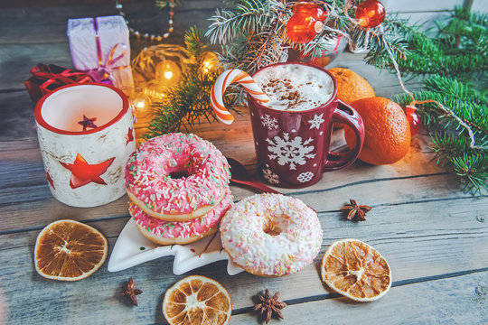Pink donuts lie on the Christmas table next to eggnog and tangerines. new year celebration