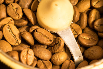 Macro photo of freshly ground coffee in electric coffee grinder. In one half whole grains of coffee, and in the other half ground.