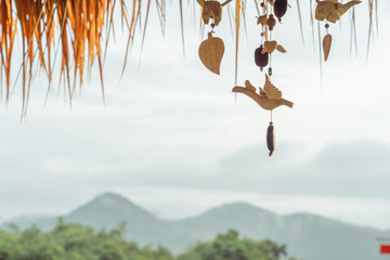 Close up Beautiful bird mobile hanging on the roof with beautiful mountain view in the morning fog.