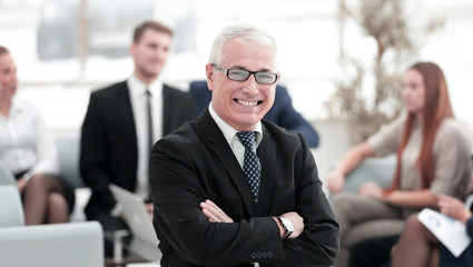portrait of senior businessman on background of office