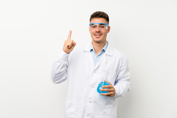 Young scientific holding laboratory flask over isolated background pointing with the index finger a great idea