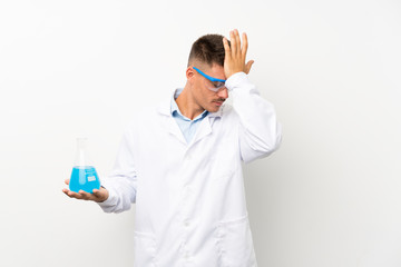 Young scientific holding laboratory flask over isolated background having doubts with confuse face expression