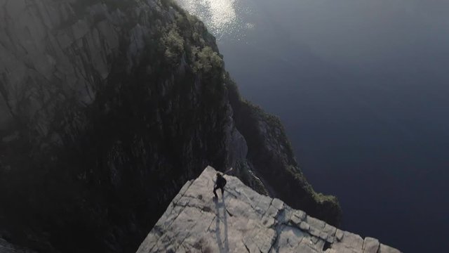 Woman standing on the edge of Preikestolen (Pulpit Rock), Norway