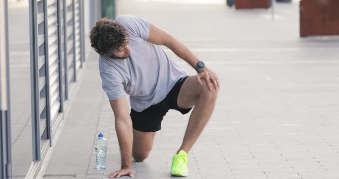 Modern woman and man jogging / exercising in urban surroundings and using cellphone at a pause / break.