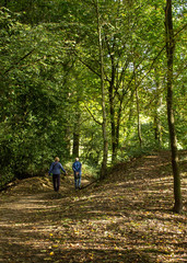 Fototapeta premium Two seniors enjoying the tranquillity of Hirst Wood in Yorkshire while getting some health giving exercise