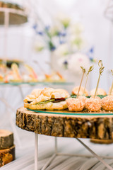 Catering service. Restaurant table with food at event. Round wooden stand with delicious snacks