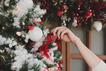Young woman decorating Christmas tree