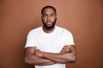 Photo of confident serious clever man standing with hands folded staring at you intently with...