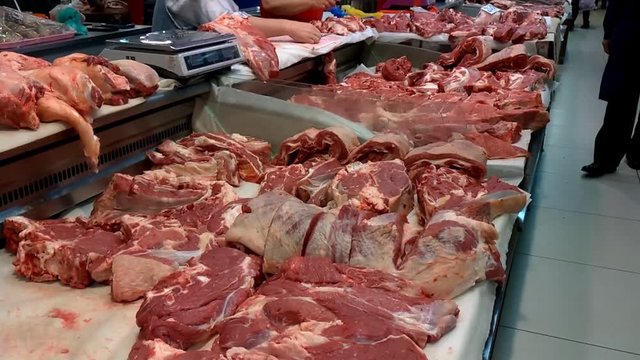Fresh Raw Meat in a counter of market. Butcher shop. Pieces of freshly cut beef or pork meat on the showcase, close up view.