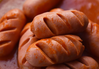 hot sausages with cuts in tomato sauce