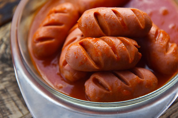 hot sausages with cuts in tomato sauce