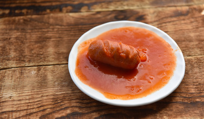 hot sausages with cuts in tomato sauce
