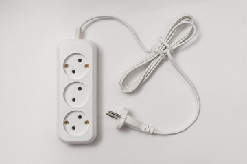 extension cord for three sockets with a long coiled cord on a white background
