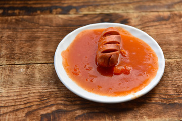 hot sausages with cuts in tomato sauce