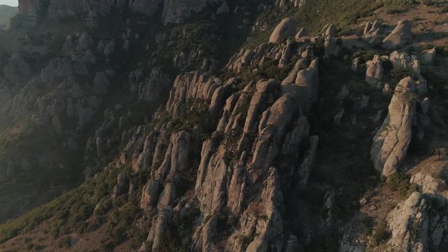 Amazing wild nature of Crimean mountains. Valley of ghosts during sunset. Forest in cliff. Birds fly above forest