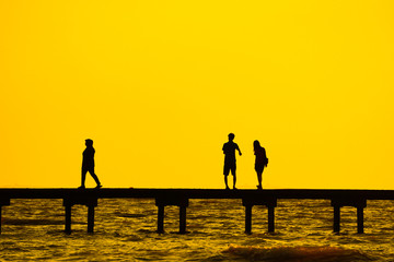 silhouette of couples over the long jetty background.