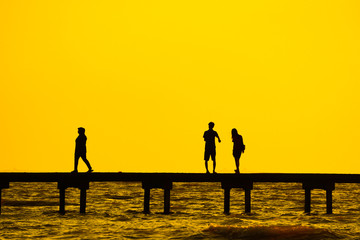 Fototapeta premium silhouette of couples over the long jetty background.