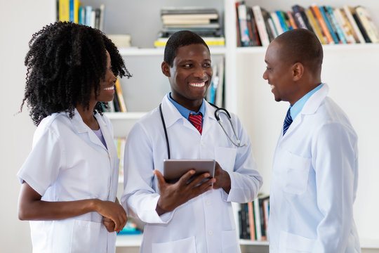 African American Doctors And Nurse Talking About Patient