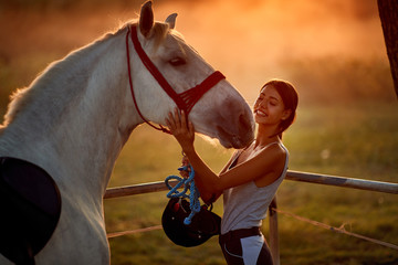 Obraz premium Girl love beautiful hourse. Woman and her horse on a sunset.