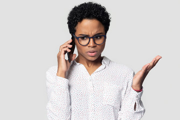 Head shot annoyed African American woman talking on phone - obrazy, fototapety, plakaty