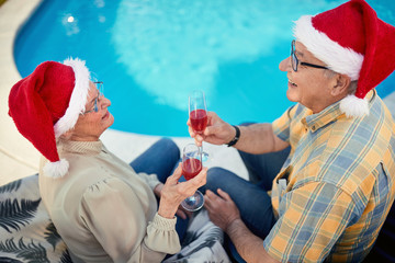 Fototapeta premium senior man and woman on christmas in Santa hats celebrate holiday