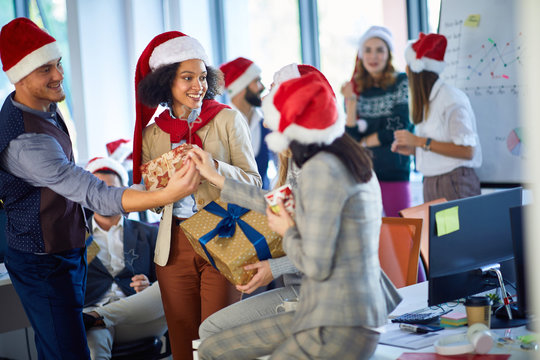 Smiling business team in santa hat at Xmas corporate party