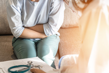 Abdominal pain patient woman having medical exam with doctor on illness from stomach cancer,...