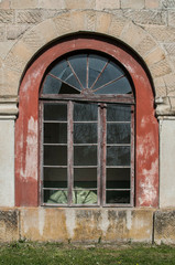 Old weathered glass church window with wooden frame closeup