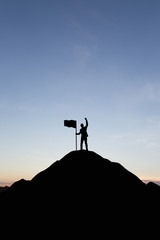 Silhouette of people and flag on top mountain, sky and sun light background. Business success and goal concept.